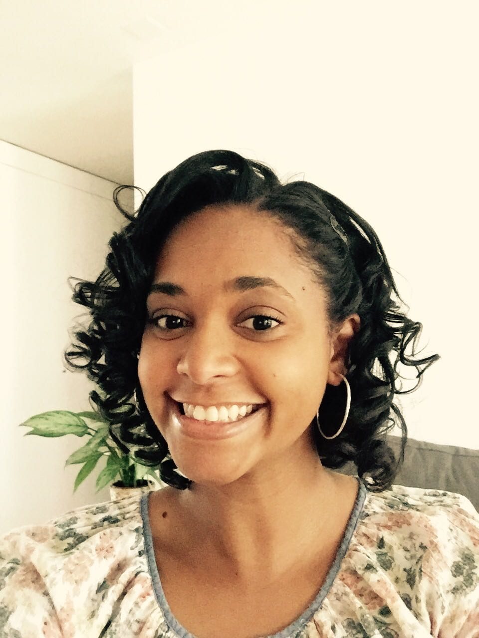 Ananda Coelho smiling, wearing a floral blouse